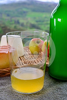 Natural Asturian cider made fromÂ fermented apples cow smoked cheese and view Picos de Europa mountains on background